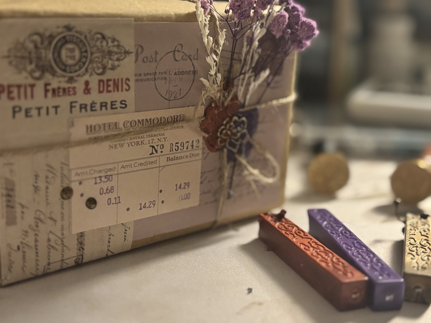 A finished Steeped & Sealed box with dried lavender, vintage ephemera, and a double wax seal